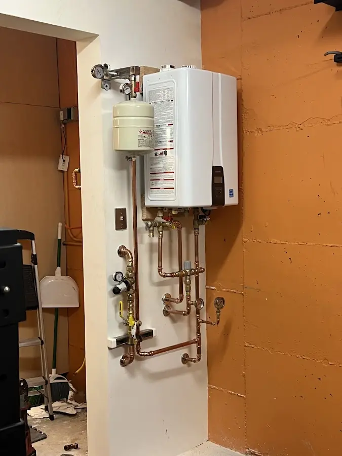 Plumbing technician inspecting water heater connections in Euless